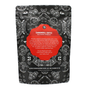 Image of the back of a packet of Cannonball Coffee. Features images of cannons, cannonballs, coffee beans and gunpowder barrels of a black background. In the middle the text reads: Wake Up and Smell the Productivity. We are a veteran owned company with a clear mission: to make strong coffee for strong people. No pretentiousness, no nonsense. Just great coffee to kick-start your day. Our beans are naturally high in caffeine without any compromise on taste. 